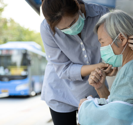 carer helping senior with her facemask