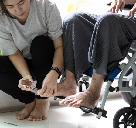 carer cutting the nails of elderly