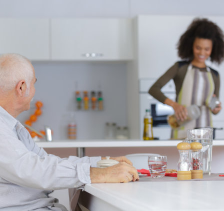 caregiver preparing meal for the elderly man