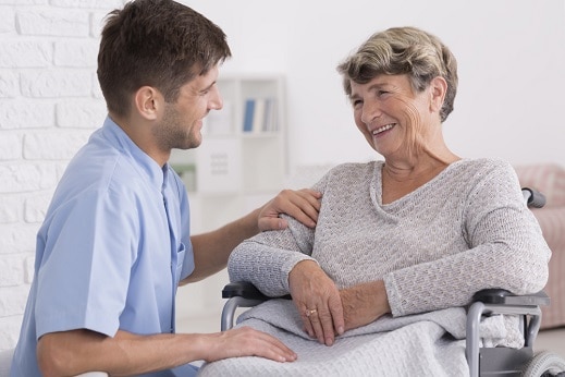 carer and senior woman smiling at each other